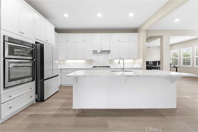 5467 Lisboa St, Chino Hills, CA 91709 - kitchen featuring a sink, appliances with stainless steel finishes, under cabinet range hood, white cabinets, and a kitchen breakfast bar