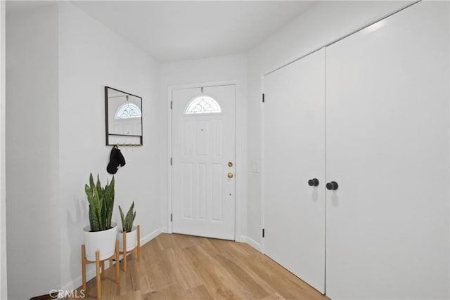 foyer with light wood-style flooring and baseboards