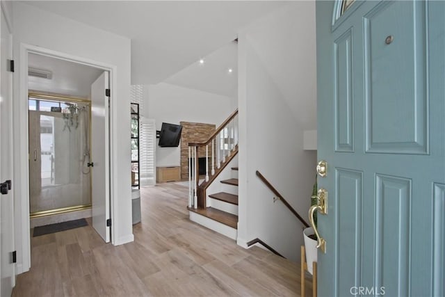foyer featuring light wood-style flooring, stairs, and baseboards