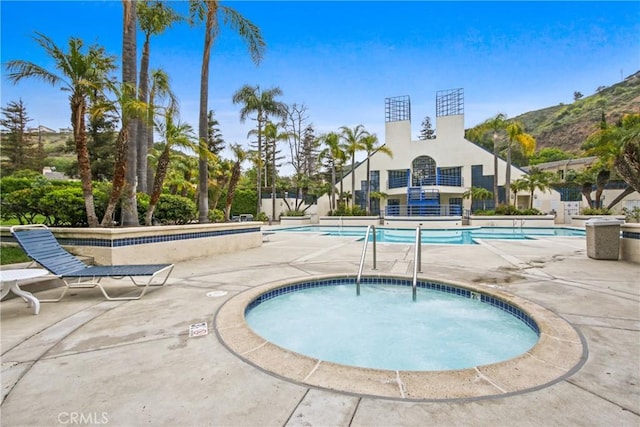 community pool with a community hot tub and a patio