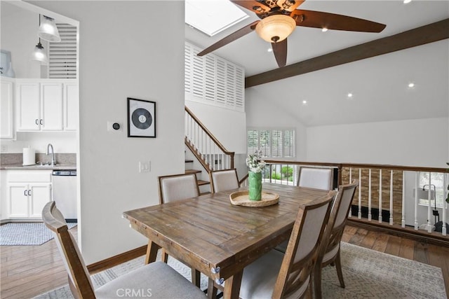 dining room with a ceiling fan, hardwood / wood-style floors, stairway, a skylight, and recessed lighting