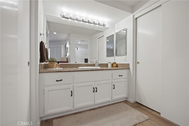bathroom with wood finished floors and vanity