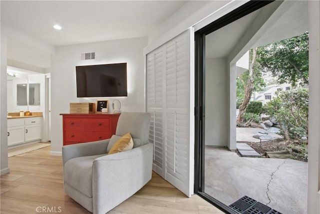 living area featuring light wood finished floors and recessed lighting