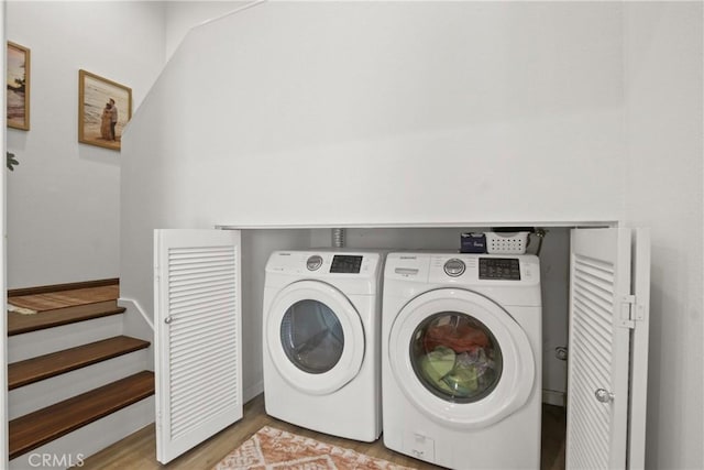 laundry room with washer and dryer and light wood-style floors