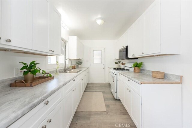 1949 Lancewood Ave, Hacienda Heights, CA 91745 - kitchen with white gas stove, light wood finished floors, white cabinets, and light countertops