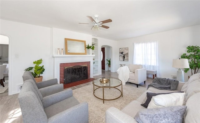 1949 Lancewood Ave, Hacienda Heights, CA 91745 - living area featuring arched walkways, wood finished floors, ceiling fan, a brick fireplace, and built in shelves