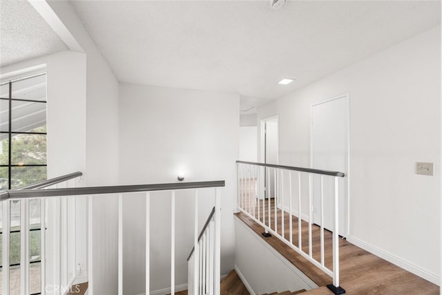 staircase featuring wood finished floors and baseboards