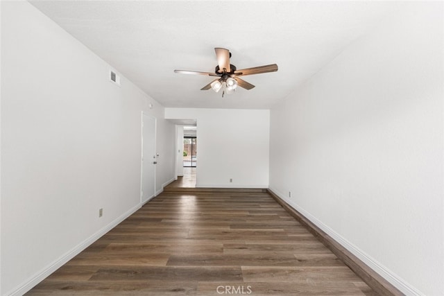 spare room featuring baseboards, visible vents, ceiling fan, and wood finished floors