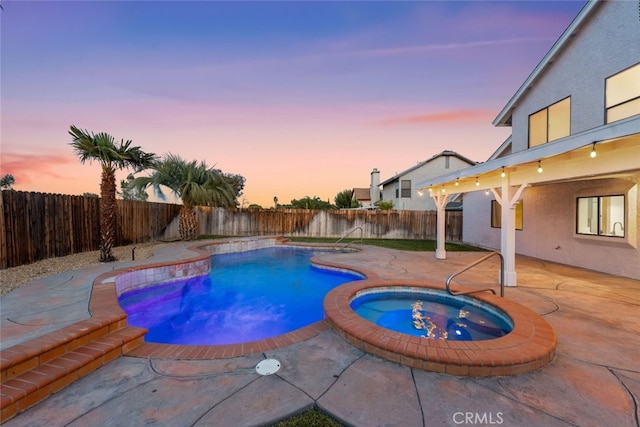 view of pool featuring a patio area, a pool with connected hot tub, and a fenced backyard