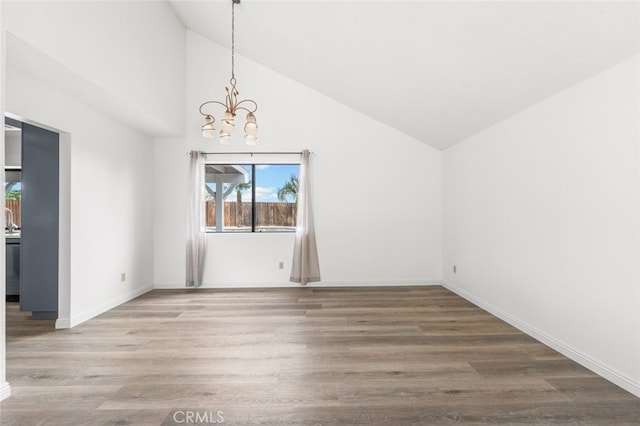 unfurnished dining area featuring a chandelier, baseboards, plenty of natural light, and wood finished floors