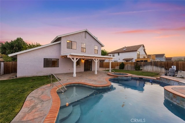 view of swimming pool with a yard, a pool with connected hot tub, a patio area, and a fenced backyard