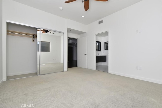 unfurnished bedroom featuring a closet, baseboards, ensuite bath, visible vents, and carpet floors