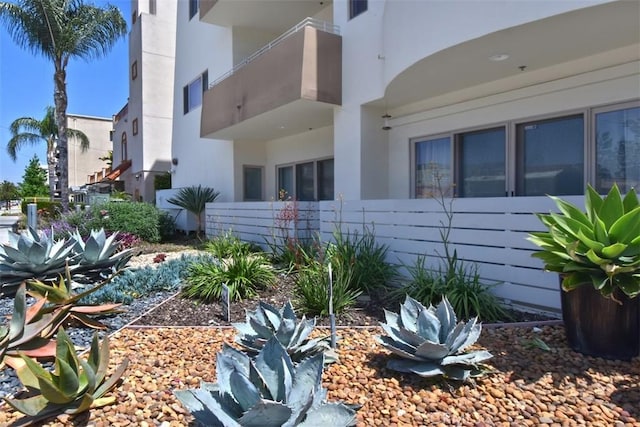 view of property exterior featuring stucco siding and fence