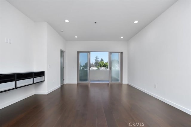spare room with wood finished floors, baseboards, and recessed lighting