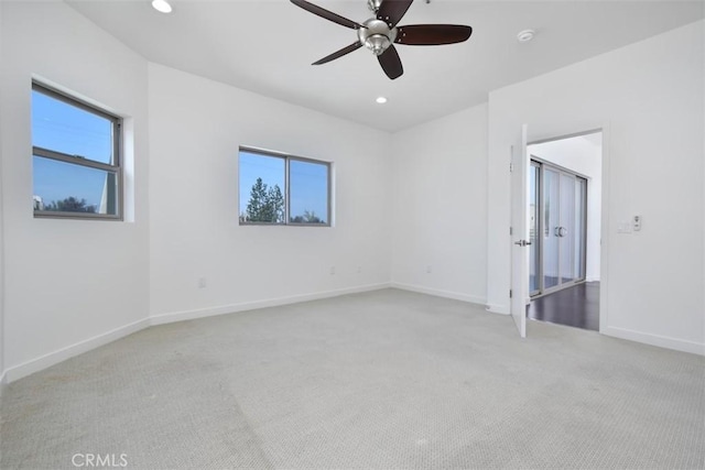 unfurnished bedroom with light colored carpet, multiple windows, and baseboards