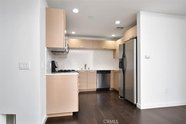kitchen with a sink, stainless steel appliances, dark wood finished floors, visible vents, and light countertops