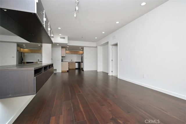 unfurnished living room featuring baseboards, recessed lighting, dark wood finished floors, and visible vents