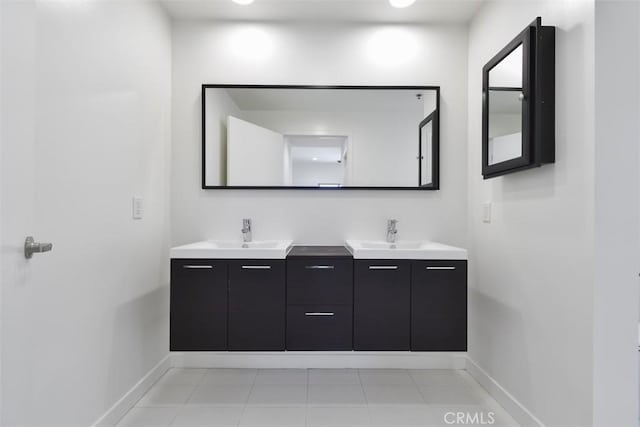 bathroom with a sink, double vanity, and baseboards