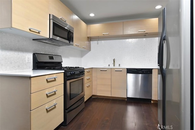 kitchen with light countertops, appliances with stainless steel finishes, light brown cabinetry, and backsplash