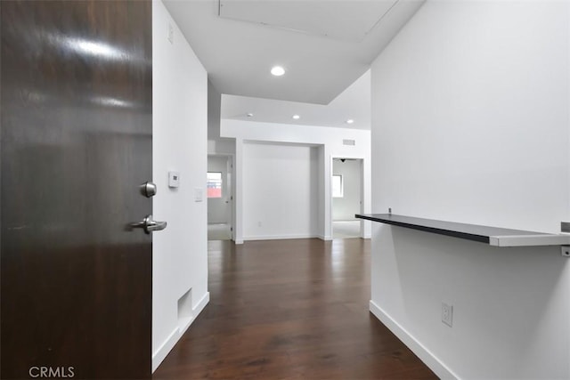 hallway with baseboards, recessed lighting, and dark wood-type flooring