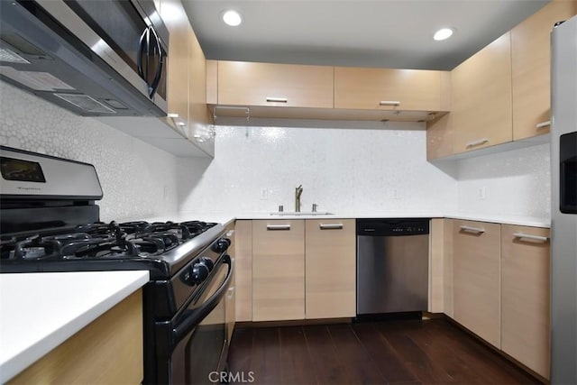 kitchen with a sink, stainless steel appliances, dark wood-style flooring, light countertops, and tasteful backsplash