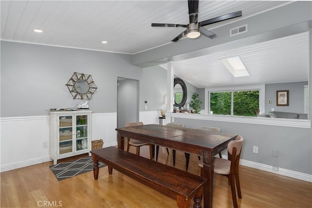 dining space featuring wooden ceiling, visible vents, wainscoting, and light wood-style floors