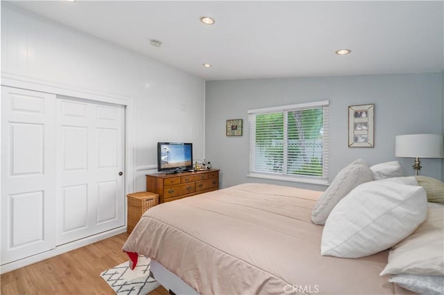 bedroom with recessed lighting, a closet, and light wood-style floors