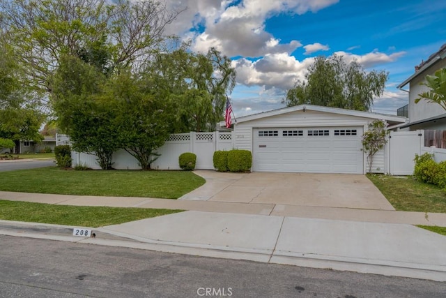 ranch-style home with fence, a detached garage, and a front lawn