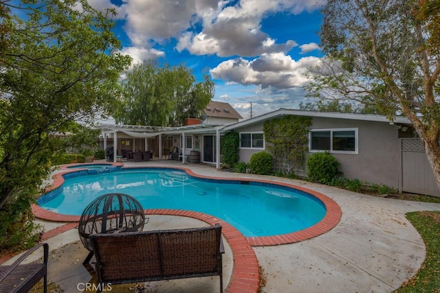 view of pool with a patio, a pool with connected hot tub, and a pergola