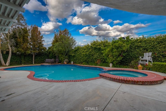 view of swimming pool with a patio and a pool with connected hot tub