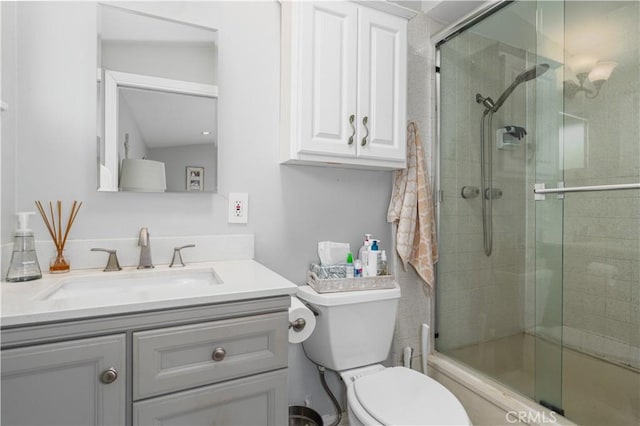 full bath with vanity, toilet, and a tile shower