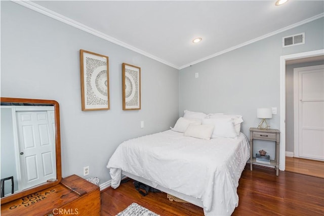 bedroom with ornamental molding, visible vents, and wood finished floors