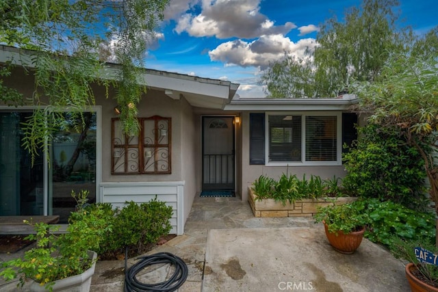 property entrance with stucco siding
