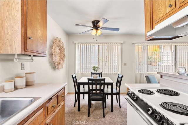 660 Stanley Ave, Long Beach, CA 90814 - kitchen featuring brown cabinetry, light colored carpet, under cabinet range hood, a ceiling fan, and electric range