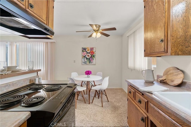 660 Stanley Ave, Long Beach, CA 90814 - kitchen featuring under cabinet range hood, brown cabinetry, ceiling fan, black range with electric cooktop, and carpet floors