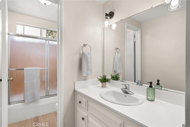 660 Stanley Ave, Long Beach, CA 90814 - full bathroom with toilet, vanity, wood finished floors, and bath / shower combo with glass door