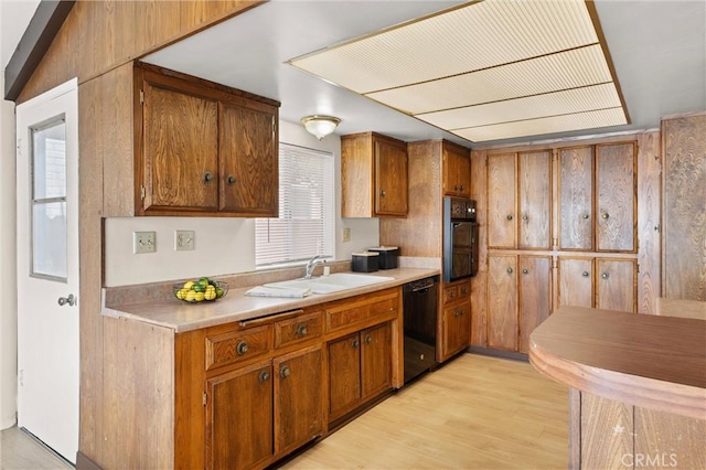 660 Stanley Ave, Long Beach, CA 90814 - kitchen with brown cabinets, a sink, black appliances, light countertops, and light wood-style floors