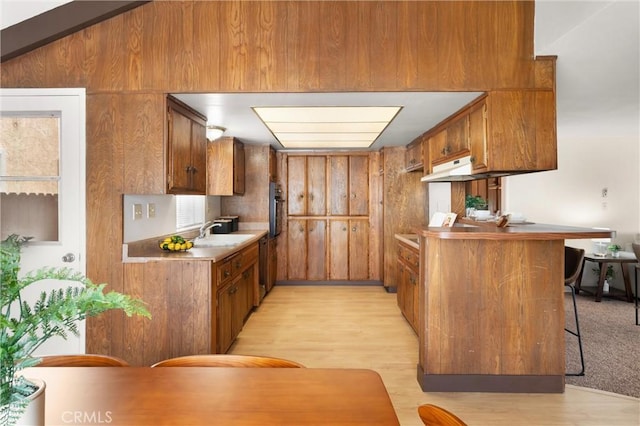 660 Stanley Ave, Long Beach, CA 90814 - kitchen featuring a sink, brown cabinetry, a breakfast bar, oven, and light wood-type flooring