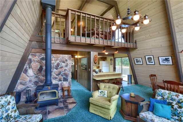 60027 Cascadel Dr S, North Fork, CA 93643 - carpeted living room with a wood stove, wood walls, high vaulted ceiling, and wood ceiling with exposed beams