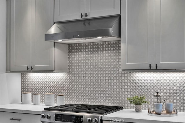 21820 Dumetz Rd, Woodland Hills, CA 91364 - kitchen with under cabinet range hood, stainless steel range with gas cooktop, and tasteful backsplash