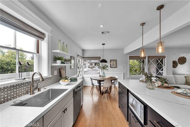 21820 Dumetz Rd, Woodland Hills, CA 91364 - kitchen with a sink, stainless steel appliances, light wood finished floors, hanging light fixtures, and light stone counters