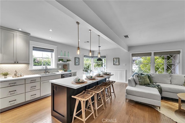 21820 Dumetz Rd, Woodland Hills, CA 91364 - kitchen with plenty of natural light, a breakfast bar area, open floor plan, a kitchen island, and wainscoting