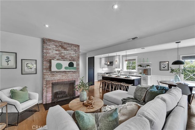 21820 Dumetz Rd, Woodland Hills, CA 91364 - living area with wood finished floors, a brick fireplace, and recessed lighting