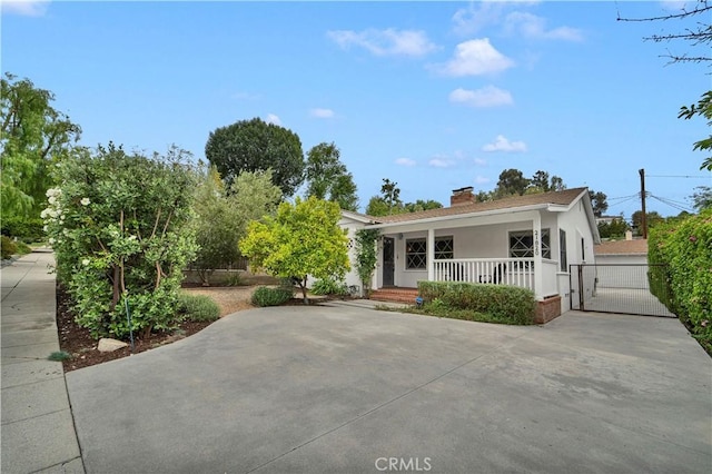 21820 Dumetz Rd, Woodland Hills, CA 91364 - view of front facade with covered porch, stucco siding, a chimney, and a gate