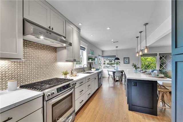 21820 Dumetz Rd, Woodland Hills, CA 91364 - kitchen featuring under cabinet range hood, stainless steel gas stove, a sink, healthy amount of natural light, and recessed lighting