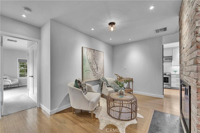 21820 Dumetz Rd, Woodland Hills, CA 91364 - sitting room featuring light wood-style flooring, a large fireplace, and recessed lighting
