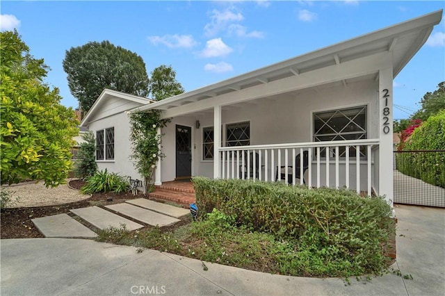 21820 Dumetz Rd, Woodland Hills, CA 91364 - view of front of house featuring stucco siding, a porch, and fence