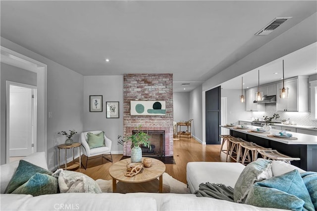 21820 Dumetz Rd, Woodland Hills, CA 91364 - living area featuring light wood finished floors, a fireplace, baseboards, and recessed lighting