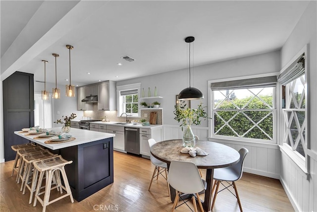 21820 Dumetz Rd, Woodland Hills, CA 91364 - kitchen featuring appliances with stainless steel finishes, under cabinet range hood, light countertops, open shelves, and a center island