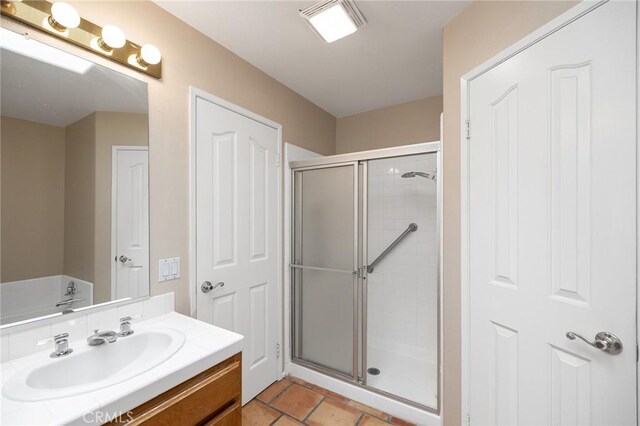 full bath featuring tile patterned floors, vanity, visible vents, and a stall shower